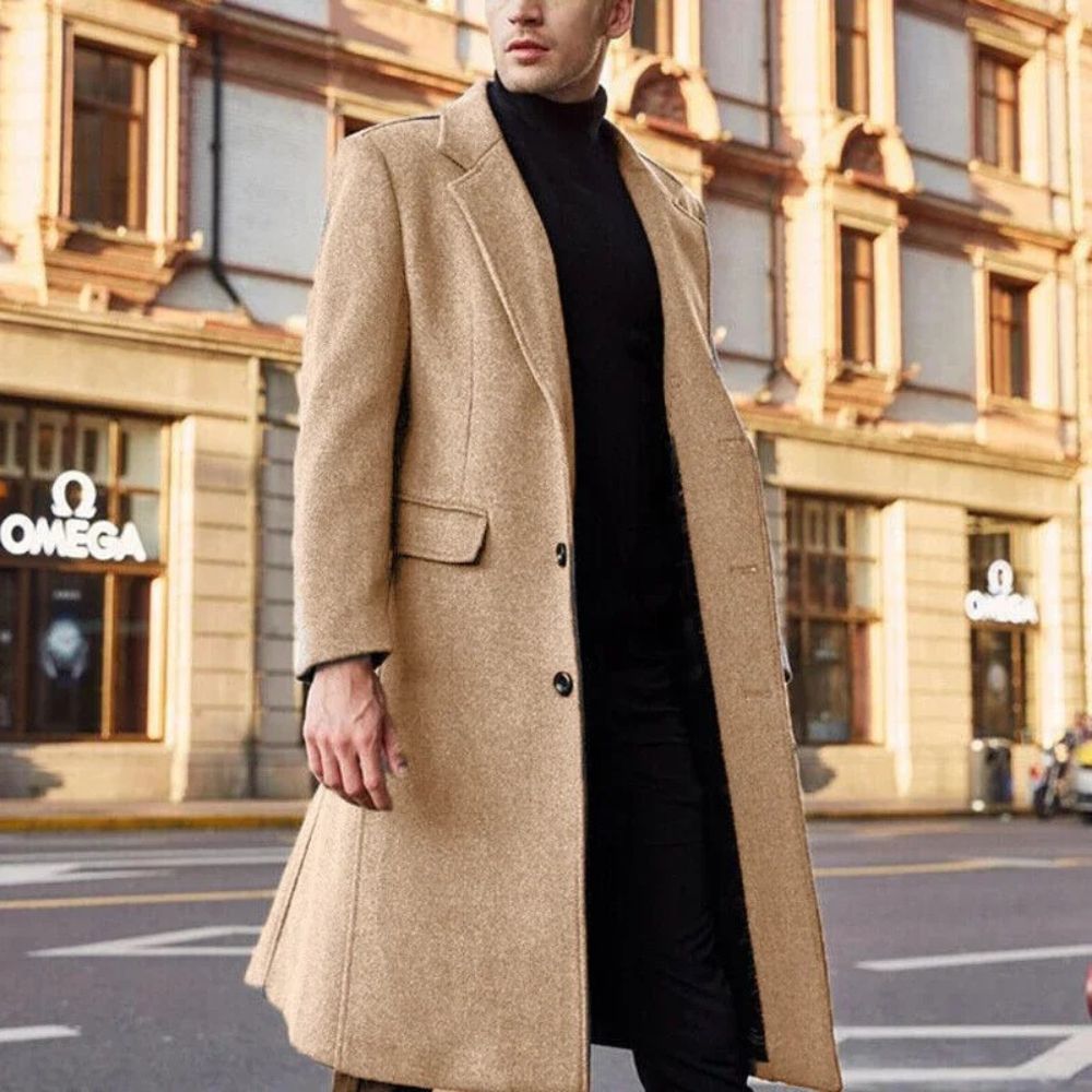 Hombre vistiendo un elegante abrigo largo de invierno, ideal para días de otoño e invierno.