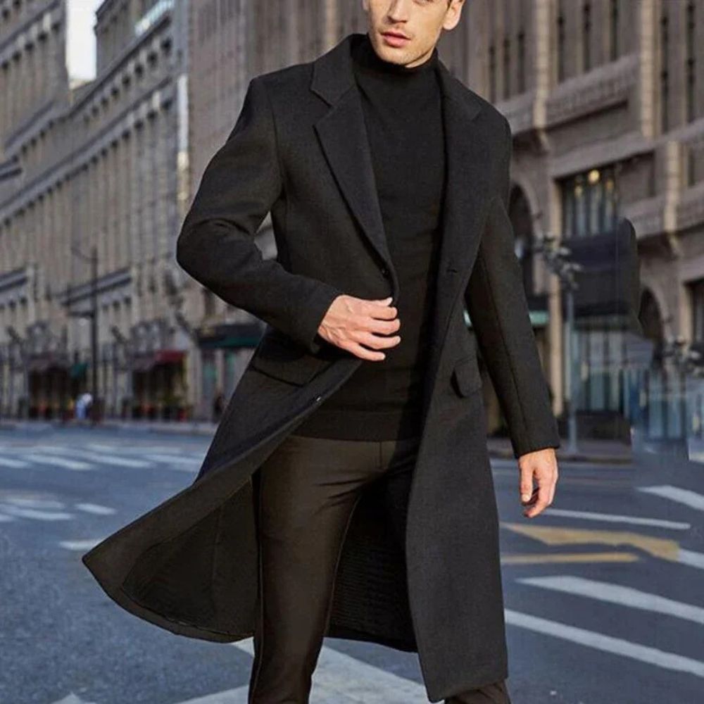 Hombre vistiendo un elegante abrigo largo de invierno, ideal para días de otoño e invierno.